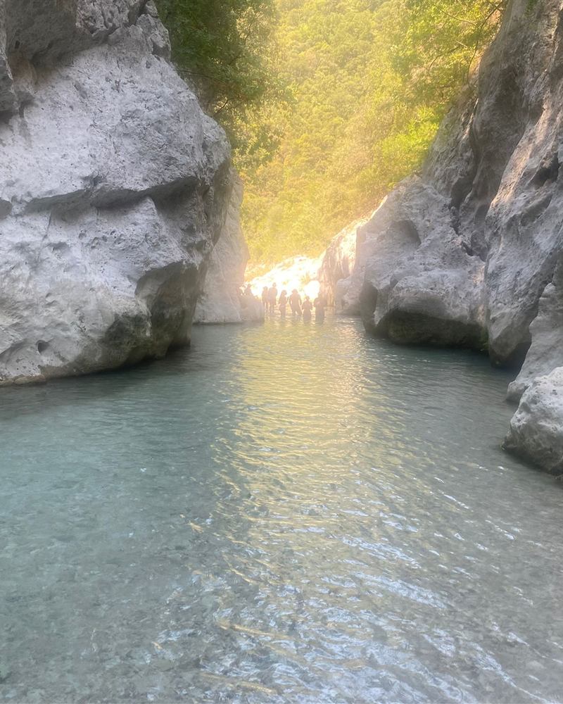 A small group wading up the sunlit Acheron gorge