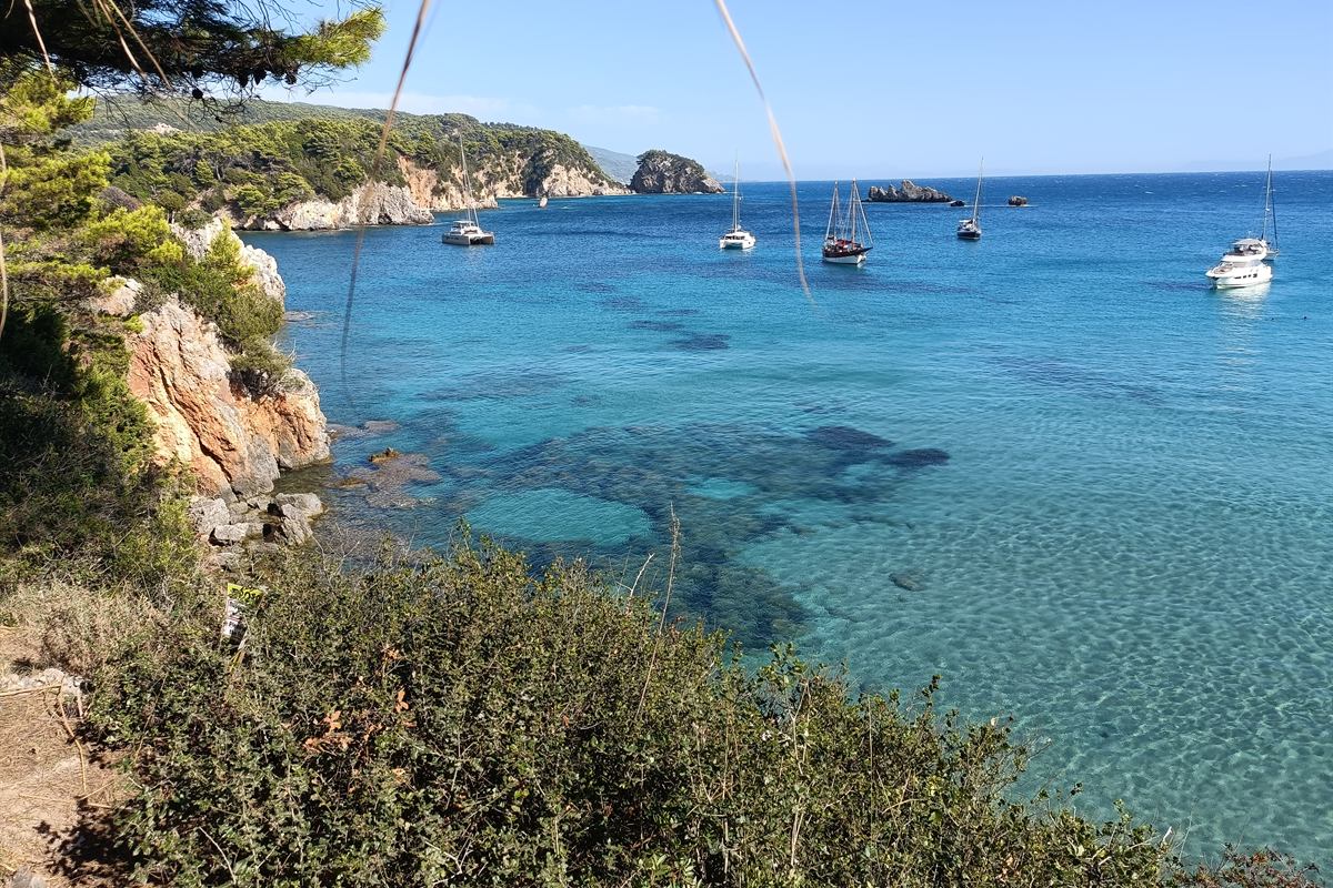 Sailboats anchored in a turquoise bay of the Ionian sea